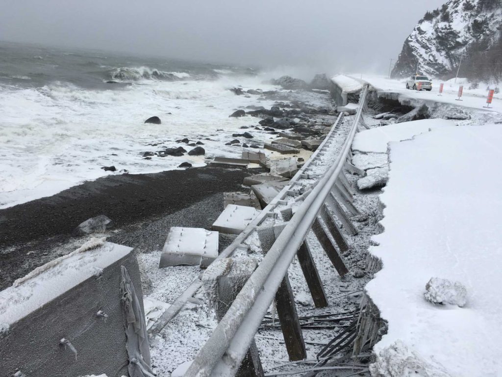 Photograph of a section of Route 132 in the winter where the road and guardrail have been washed into the river in La Martre, Gaspé.